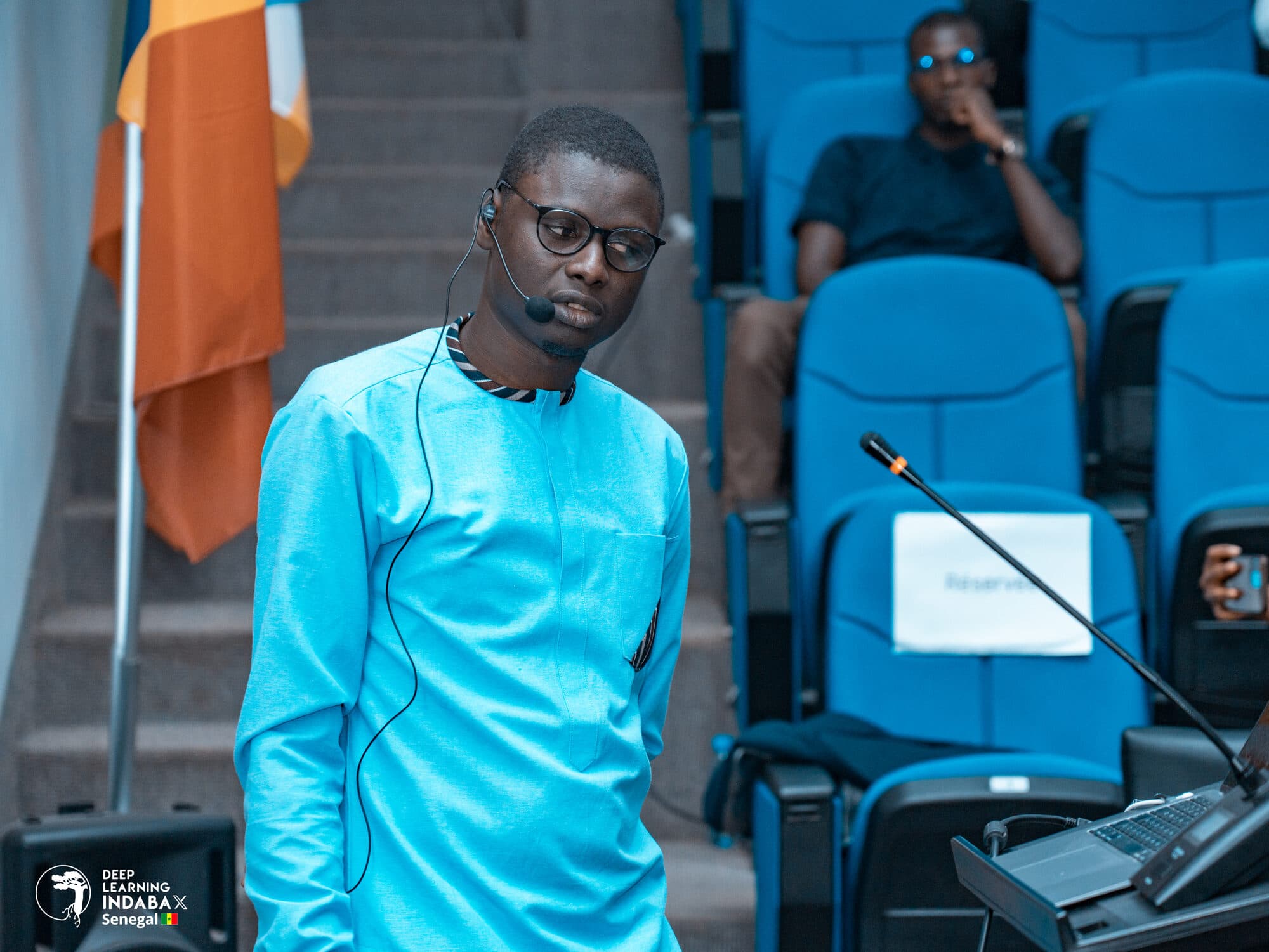 Un participant debout près des sièges de l'amphithéâtre
